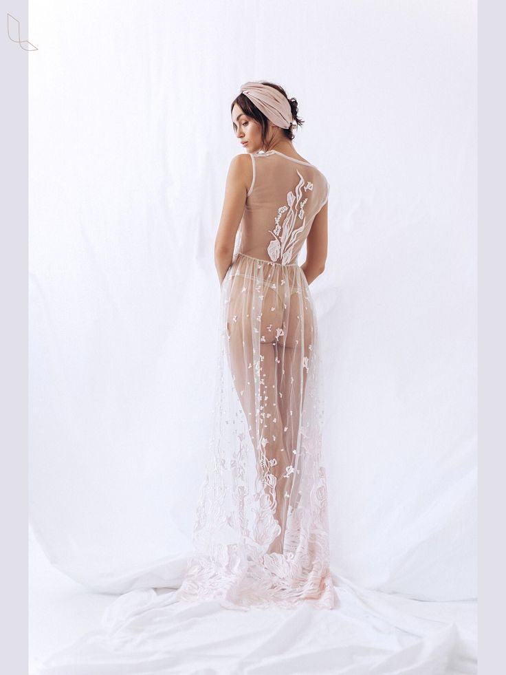 This BLUSH sheer bridal gown is designed to accentuate the style of the bride. The Boudoir wedding dress is made by hand. We will make this sheer bridal robe for bride in one of the standard sizes or according to your parameters.  This robe can be perfectly used for maternity photo shoot. In this way we rise waist line of the dress under bust. Production time for this long lace boudoire robe is 5-10 business days after receiving payment and confirming the size. If you are in a hurry, please let us know. All our items we send in gorgeous boxes. We strive for customer satisfaction! You can ask any question or suggest a change of a part or a certain color of order before shipment, I will be happy to answer any questions about this simple wedding dress. It is in light pink color. Luxury Wedding Night Gown With Sheer Bodice, Tulle Wedding Gown With Sheer Back, Wedding Gown With Sheer Back And Fitted Bodice, Feminine Organza Wedding Gown, Ethereal Tulle Wedding Gown, Feminine Wedding Gown With Fitted Bodice, Ethereal Fitted Sheer Gown, White Ethereal Gown For Party, White Ethereal Party Gown