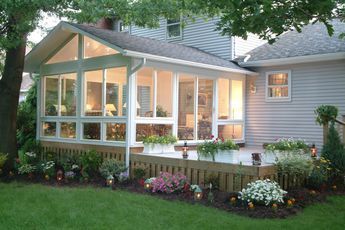 a house that has some flowers in the front yard and on the side of it