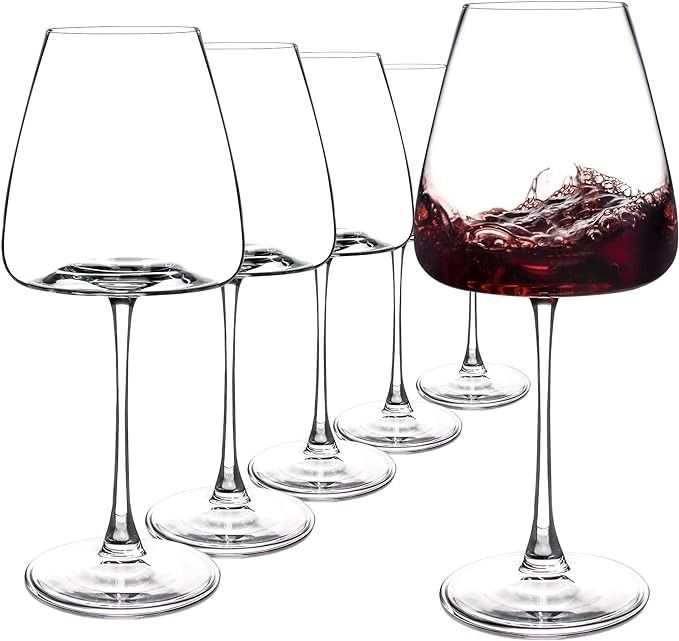 four wine glasses filled with red wine and ice on a white background, set next to each other