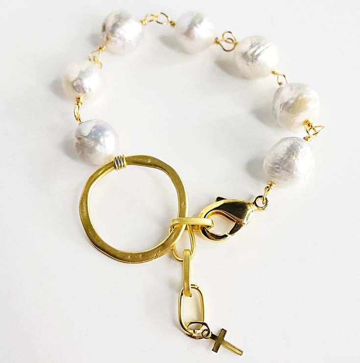 You want unique, you want different, you want elegant? This bracelet is all of those. It is a beautiful high grade Keshi pearl, hand-chained with 14kt gold wire, that is brought together in the center by a beautiful gold ring and at the end a beautiful three link chain lets it fit most all sizes. Clasp it on the circle or use the chain. At the end of the chain there is a beautiful 14kt gold cross reminding us of God's wisdom that is ready and available for us. Adjustable from approximately 6.5 i Metal Bracelets With Pearl Drop For Gift, White 14k Gold-filled Bracelets With Pearl Chain, White 14k Gold Filled Pearl Chain Bracelets, White 14k Gold Filled Pearl Chain Bracelet, Adjustable Gold Bracelet With Pearl Charm, Adjustable Gold Pearl Bracelet With Pearl Charm, Adjustable Chain Bracelet With Pearl Drop, Adjustable Pearl Drop Chain Bracelet, Handmade 14k Gold-filled Pearl Bracelet