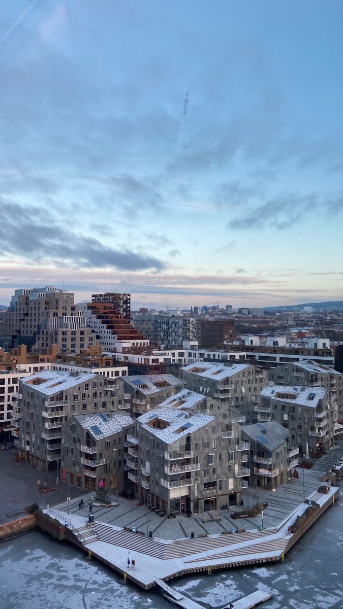 an aerial view of a city with buildings and ice on the water in front of it