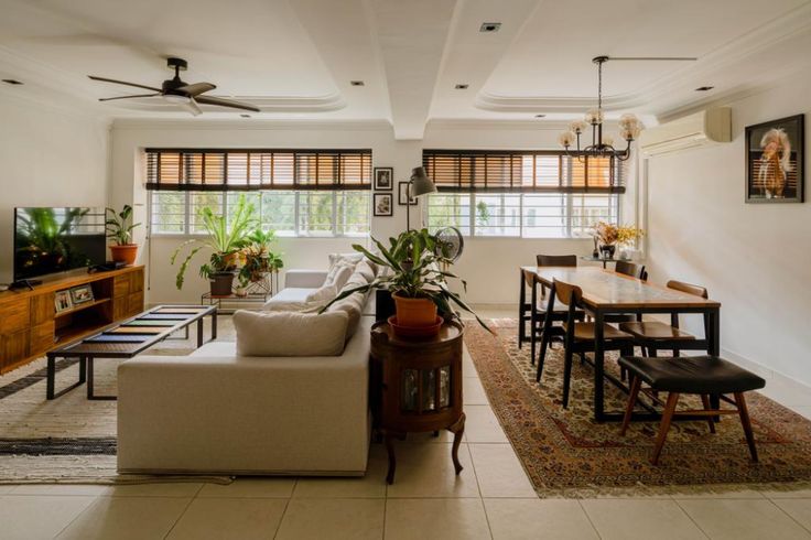 a living room filled with furniture and a flat screen tv on top of a wooden table