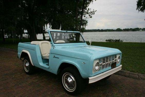 an old pick up truck is parked by the water