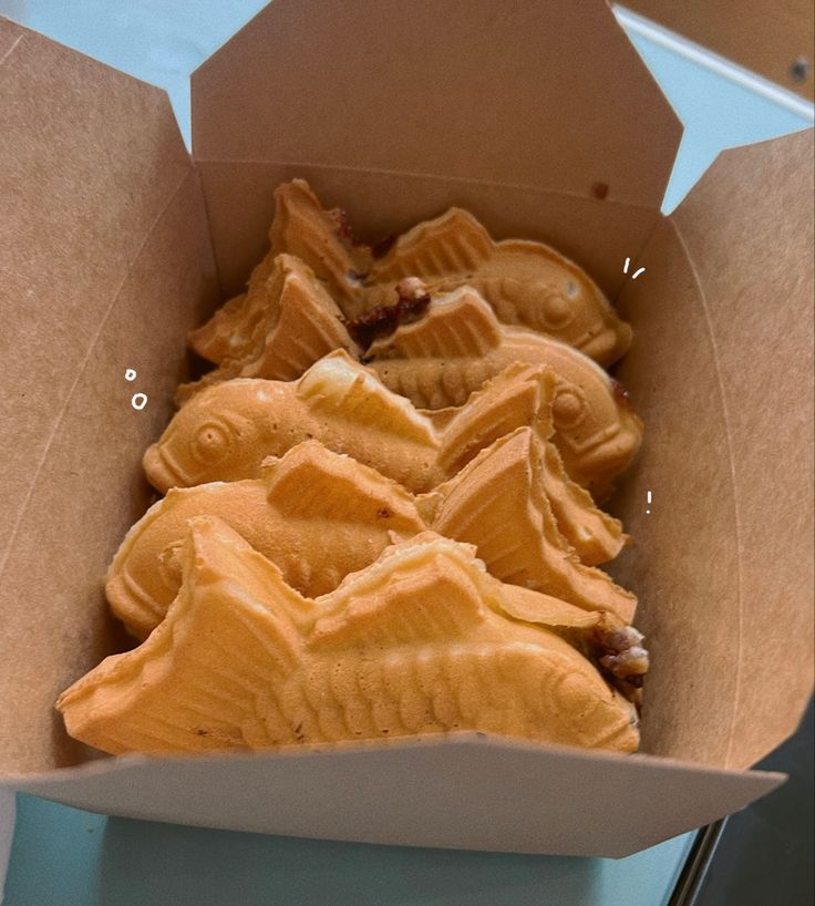 some kind of food that is in a box on a table and it looks like fish