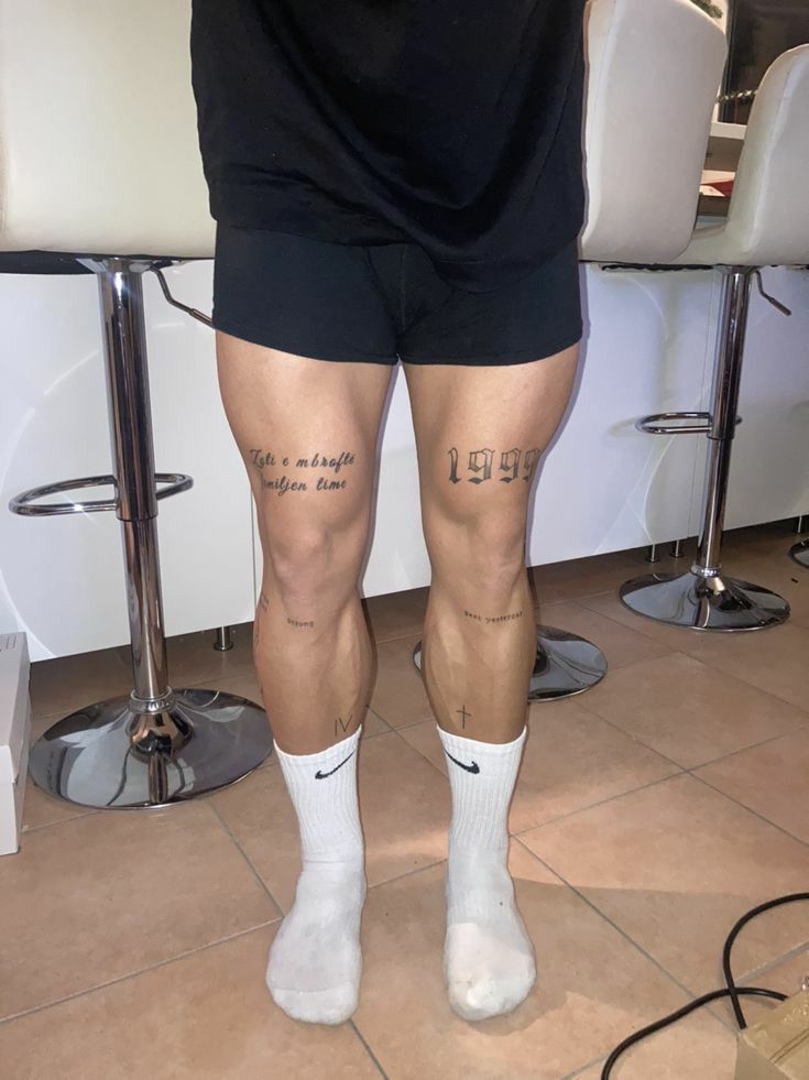 the legs and ankles of a man with tattoos on them