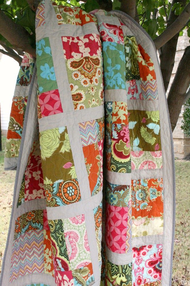 a patchwork quilt hanging from a tree