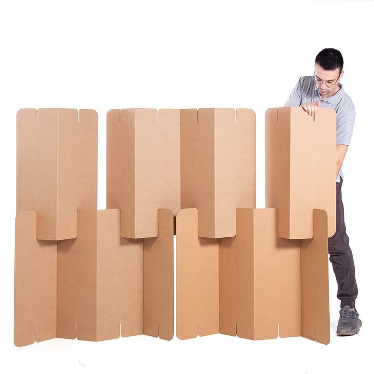 a man is leaning against cardboard boxes and looking at the wall with his hand on it