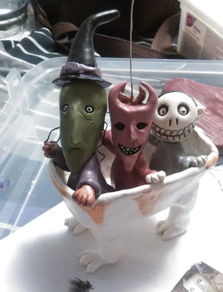 three halloween figurines sitting in a bathtub