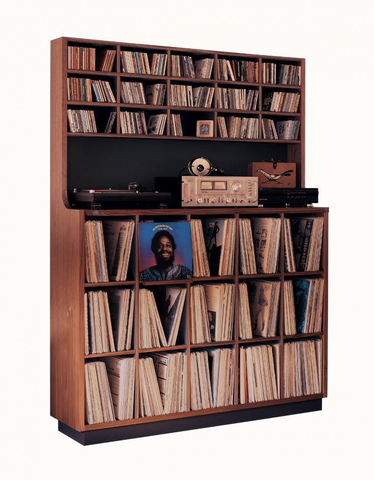 an old record player is sitting in front of a bookcase filled with vinyl records