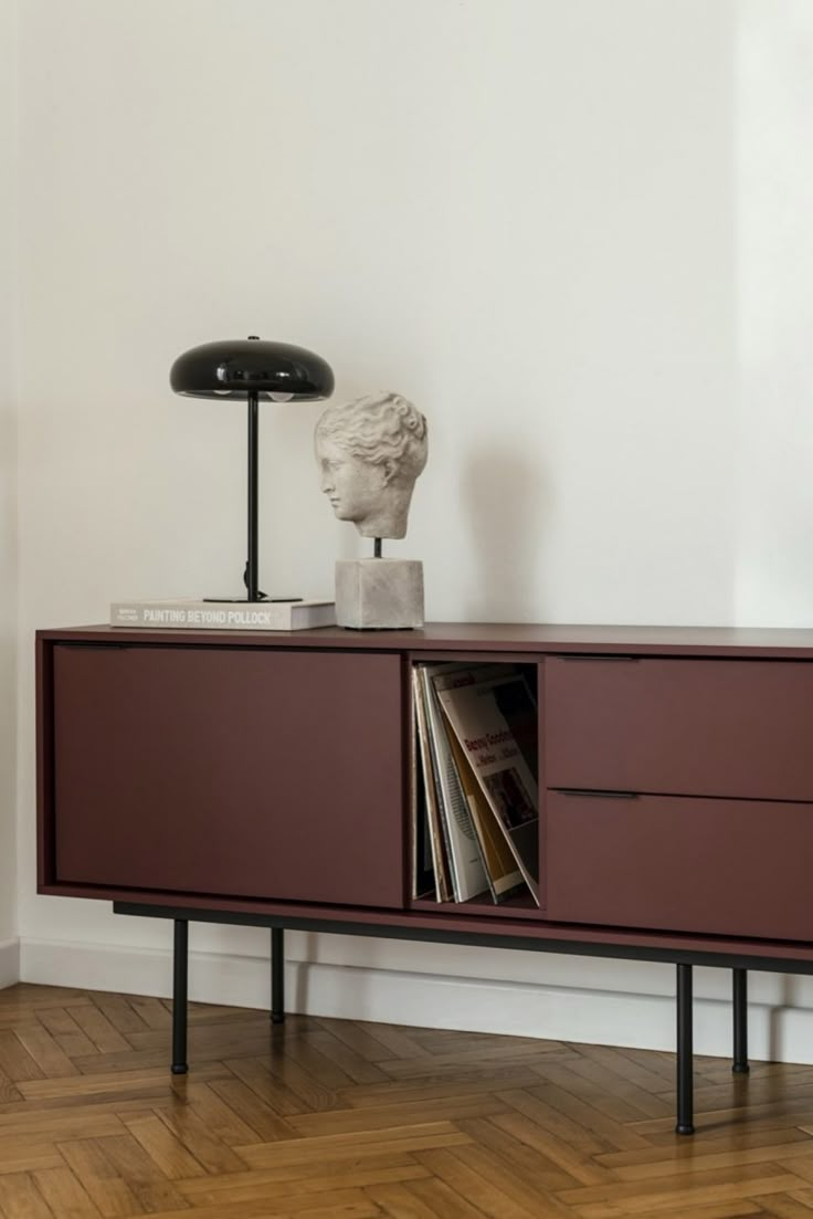 a sideboard with books and a lamp on top