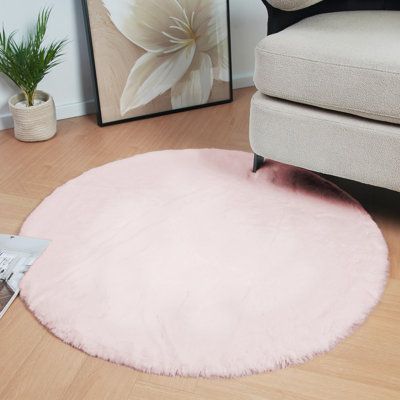 a pink rug is on the floor next to a chair