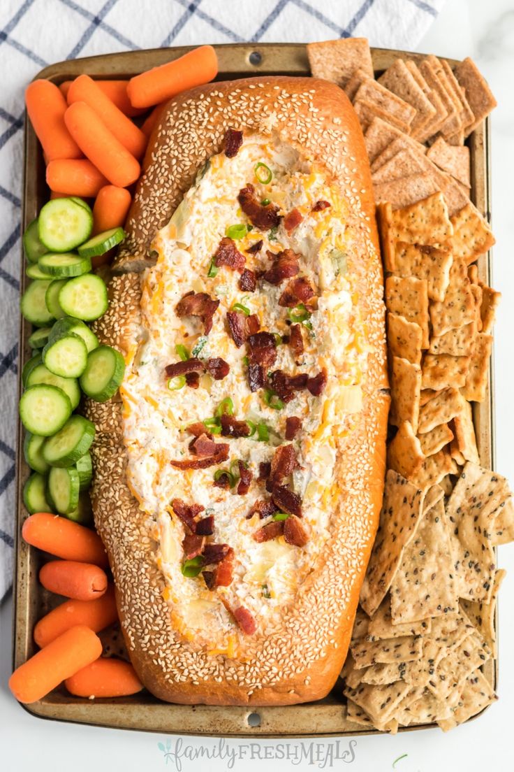 a platter filled with bread, crackers and vegetables