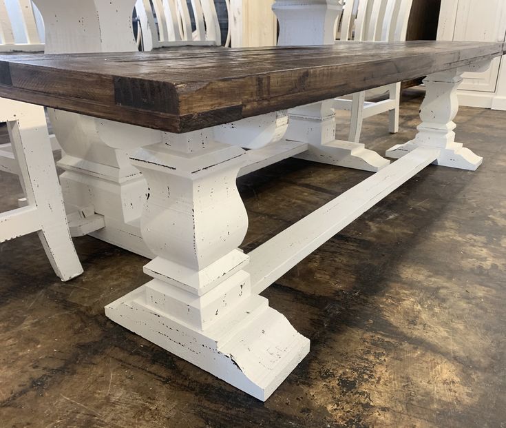 a white table and chairs in a room with wood flooring on one side and wooden top on the other