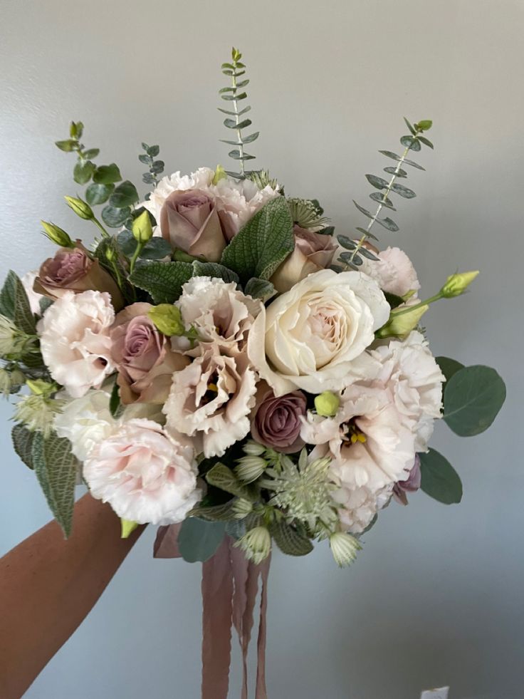 a vase filled with lots of flowers on top of a table