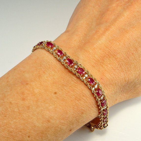 Here we have an astonishing natural no heat vivid red ruby and sparkly diamond bracelet crafted in solid 14K yellow and white gold. This bracelet has an extraordinary amount of work in it to handmade so many of the delicate links and assemble them. It is beautifully made and this fact means it drapes beautifully around the wrist line. Like all the best luxury jewelry this feels beautiful to wear. In total it weighs approximately 13 grams. The clasp is marked 14K and professional testing does con Luxury Red Diamond Jubilee Bracelet, Red Ruby Round Bracelets, Ruby Gemstone Tennis Bracelet, Red Ruby Round Bracelet, Red Ruby Bracelets, Yellow Gold Ruby Bangle Bracelets, Luxury Red Ruby Tennis Bracelet, Red Diamond Bracelet With Gemstone, Ruby Bangle Bracelet In Yellow Gold