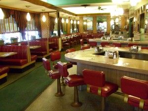 the interior of a restaurant with red leather chairs and green carpeted flooring is shown