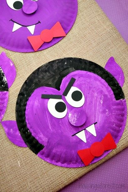 two paper plates with purple monster faces on them