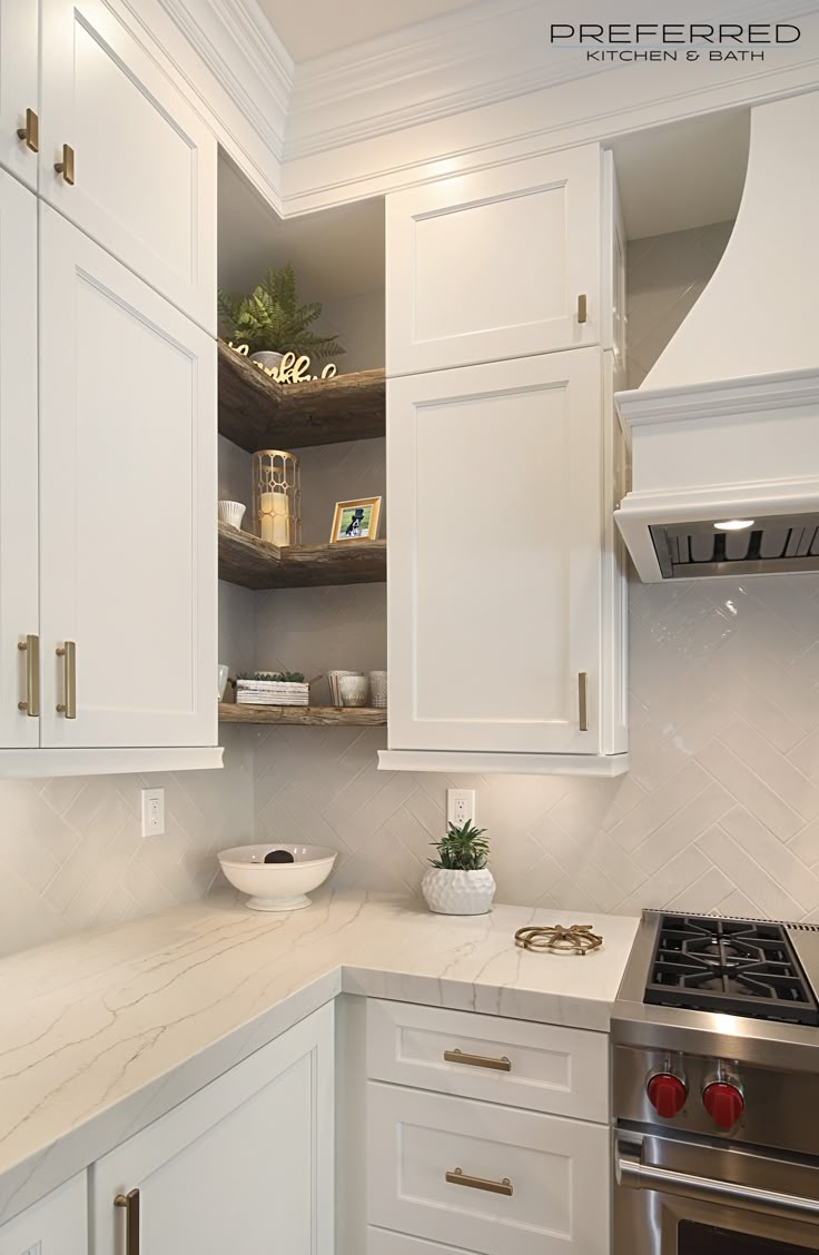 a kitchen with white cabinets and marble counter tops in the corner, along with a stainless steel stove top oven