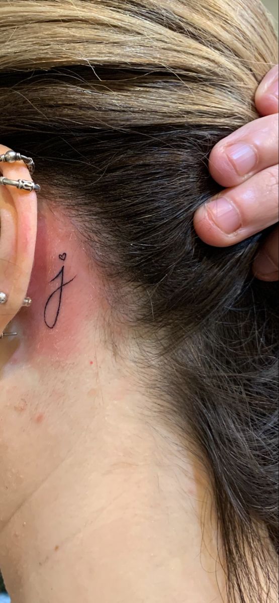 a woman with a small tattoo behind her ear