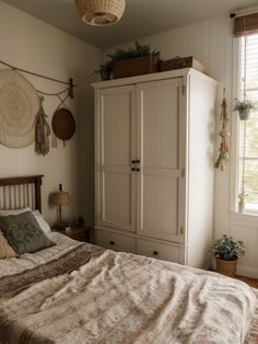 a bedroom with a bed, dresser and hanging baskets on the wall above it's headboard