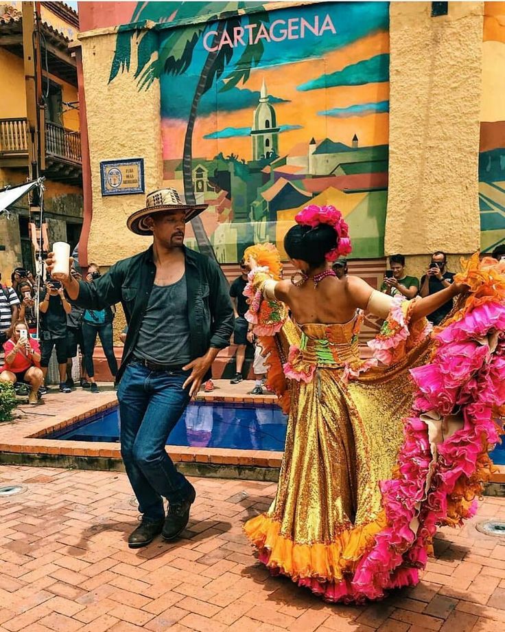 a man and woman dancing in front of a building