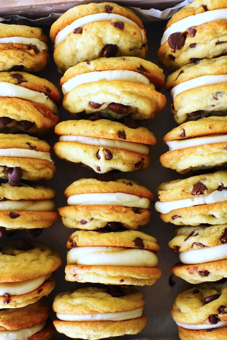 chocolate chip cookies with white frosting and chocolate chips on top are arranged in rows