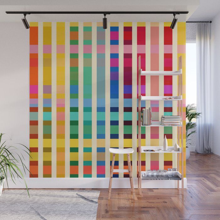 a room with a large colorful striped wallpaper on the wall and two chairs in front of it