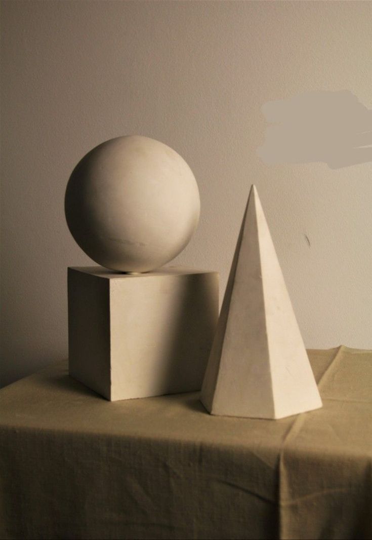 two white sculptures sitting on top of a table