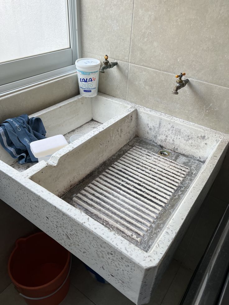 a dirty sink in a bathroom next to a window