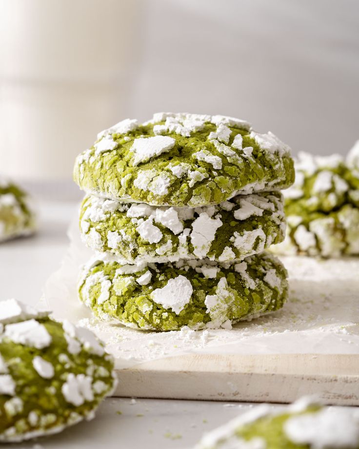 green and white cookies stacked on top of each other with powdered sugar all over them