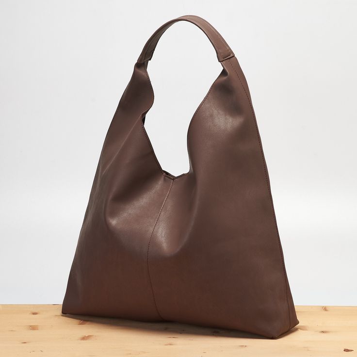 This hobo bag is made of high quality vegan leather in dark brown. It is soft and lightweight but durable. It has a rustic, distressed look. The inner side is unlined for a minimal style and it has a zippered interior pocket. it has a magnetic clasp closure for security. The strap sits on the shoulder comfortably. It has a slouchy silhouette and plenty of room for your daily needs.  Measurements Height: 320mm Width: 450mm Depth: 100mm Strap Length: 240mm // Please add your phone number to the notes section before checkout. // Thanks for your visit. Modern Brown Textured Leather Hobo Bag, Brown Faux Leather Hobo Bag For On-the-go, Brown Textured Faux Leather Shoulder Bag, Brown Textured Leather Hobo Tote Bag, Brown Soft Leather Hobo Bag For On-the-go, Brown Faux Leather Shoulder Bag With Leather Backing, Brown Textured Leather Shoulder Bag For Errands, Brown Faux Leather Hobo Bag For Daily Use, Brown Textured Leather Hobo Shoulder Bag