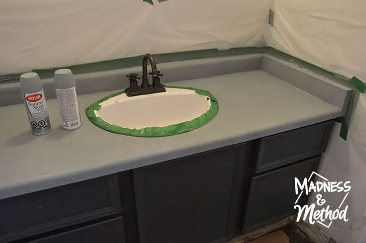 a bathroom sink with green paint on the counter