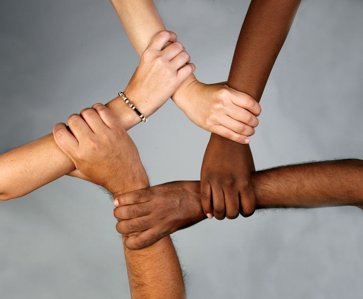 several people are holding hands together in a circle with their hands on top of each other