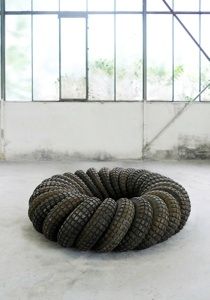 a rope sculpture sitting on top of a cement floor