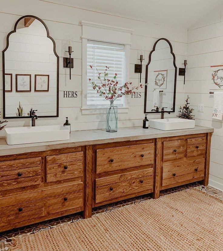 a bathroom with two sinks and mirrors on the wall