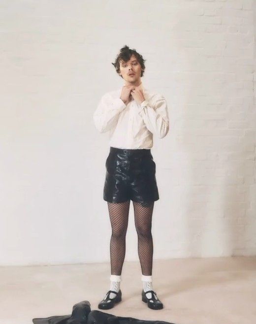 a woman standing in front of a white brick wall with her hands on her face