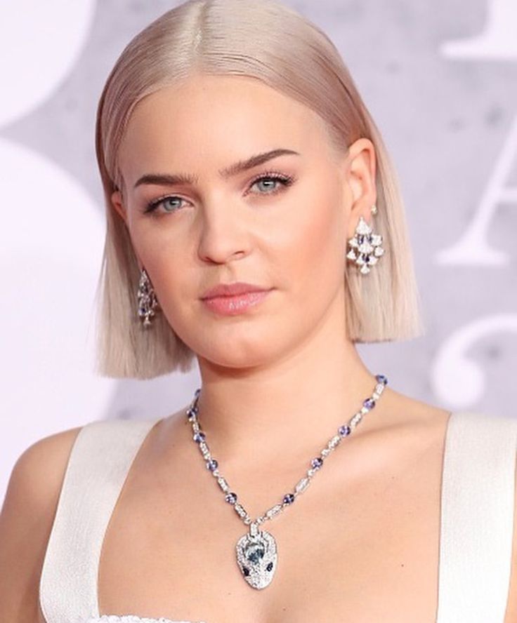 lady with blonde hair wearing a white dress and diamond necklace at the brity awards