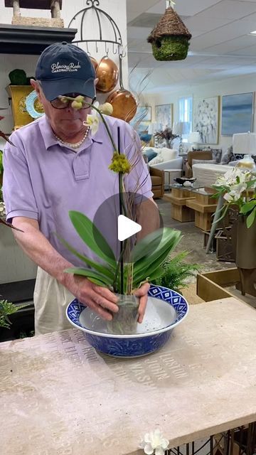 an older man is arranging flowers in a bowl