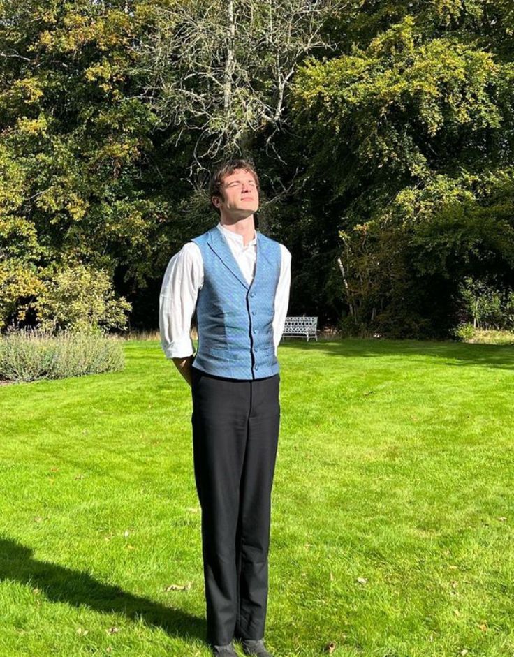 a man standing on top of a lush green field