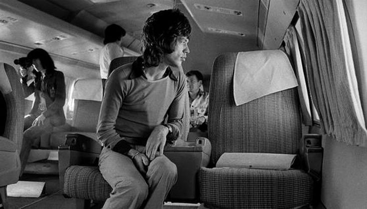 black and white photo of people sitting in an airplane