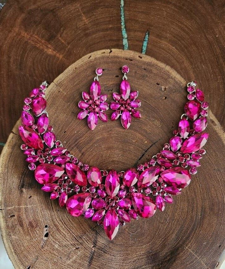 "Statement necklace and earrings set These fun and stylish pink teardrop cluster crystal rhinestone necklace and earrings set are a great statement piece!  Size of earrings: 2\" Long.  Necklace 17\"long with 3\" chain extender Decor Size: 2.5\" Color: hot pink/fuchsia rhinestones  Base metal color: silver More colors available upon request, just message us! Need a matching bracelet? https://www.etsy.com/listing/607744629/fuchsia-bracelet-hot-pink-bracelet?ref=shop_home_active_59 https://etsy.me/2UTFrJ4  https://etsy.me/2VJu5W8  https://etsy.me/3hBB6Uo  Looking for the perfect pair of earrings for a special occasion. We specialize in custom work in fashion jewelry, pearls, and natural stones! Please feel free to browse through our other listings, and if you can't find what you are looking f Pink Crystal Rhinestone Necklace, Pink Rhinestone Necklace For Party, Pink Rhinestone Jewelry Set For Party, Pink Crystal Rhinestone Necklace In Glamorous Style, Pink Teardrop Crystal Jewelry, Pink Crystal Glamorous Necklace, Pink Teardrop Necklace For Parties, Pink Crystal Jewelry Sets With Rhinestones, Glamorous Pink Rhinestone Necklace For Party