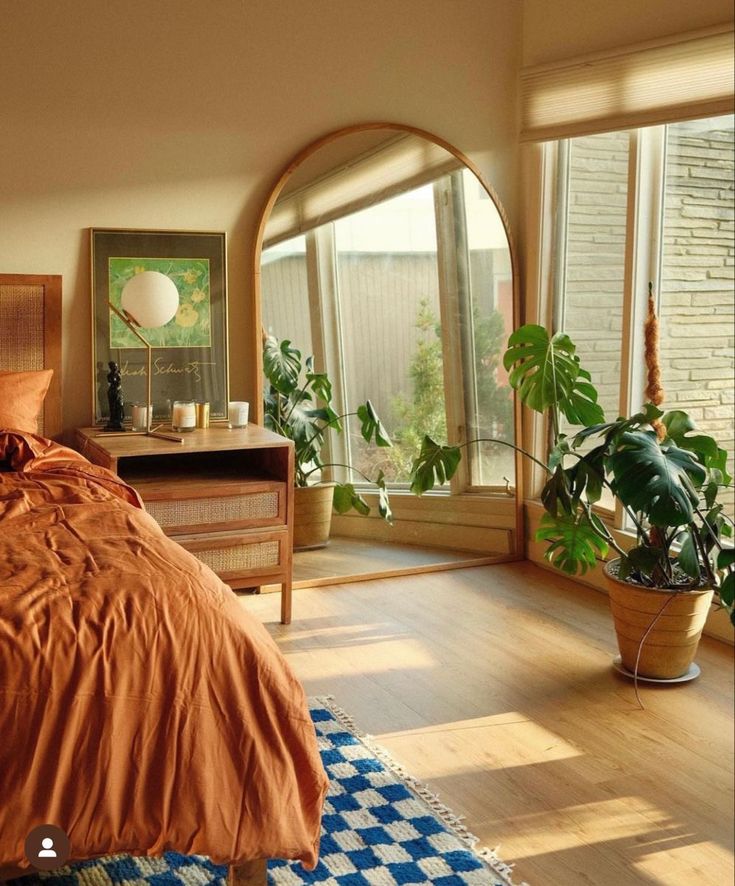 a bed room with a neatly made bed and lots of plants on the windowsill