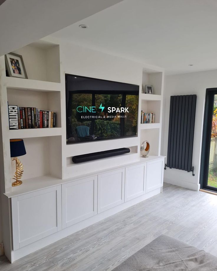 a flat screen tv sitting on top of a white entertainment center