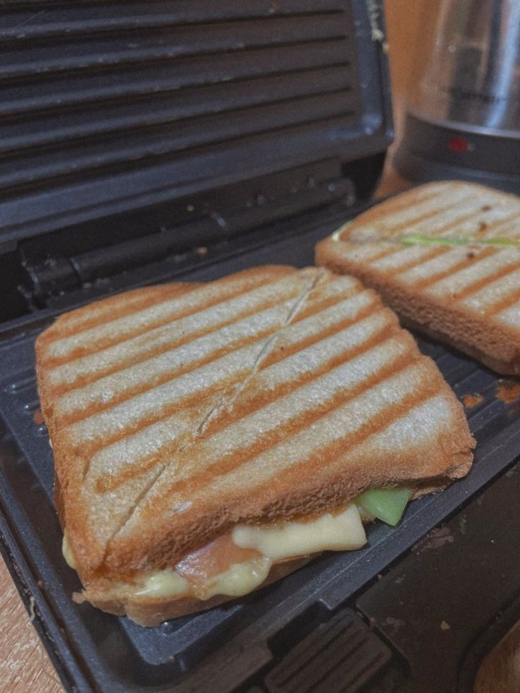 two grilled sandwiches sitting on top of an electric grill