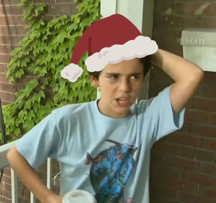 a young man wearing a santa hat on top of his head