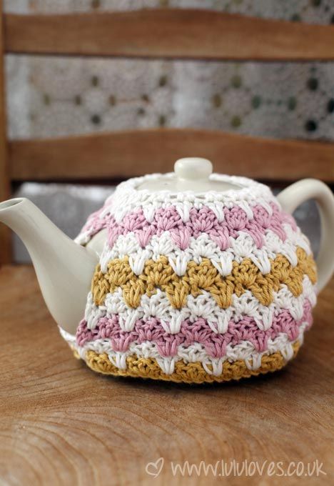 a crocheted tea pot cover sitting on top of a wooden table