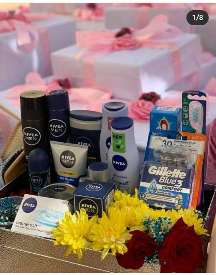 a basket filled with lots of different types of items next to flowers and gifts on a table