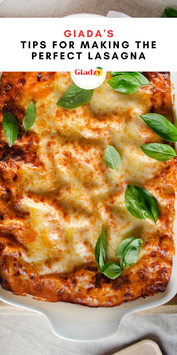 a white plate topped with a cheesy lasagna covered in cheese and basil