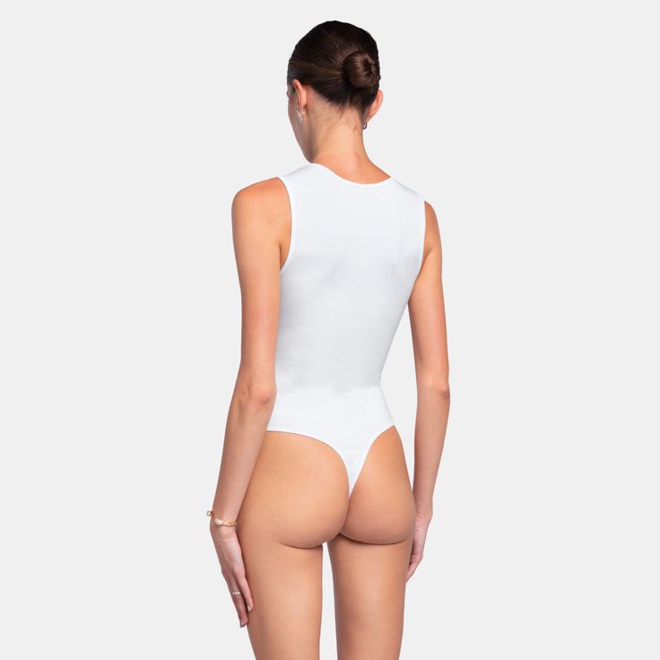 The TANKTOP Bodysuit is the perfect basic, crafted from an ultra-soft fabric blend that hugs your body flawlessly. Designed for both comfort and style, this bodysuit provides a sleek, form-fitting silhouette, making it an essential piece for any wardrobe.Size and fit:• The bodysuit runs small; we suggest sizing up• White can be slightly see-throughInfo:• 48% cotton, 48% modal, 4% spandex• Gusset hook and eye closure with thong back• Machine wash (mild detergent, iron, no bleaching, dry flat, do Chic High Cut Seamless Bodysuit, Chic Seamless Second-skin Bodysuit, High Stretch Lined Bodysuit For Loungewear, Stretch Bodysuit With Lined Body For Loungewear, High Stretch Bodysuit With Lined Body For Loungewear, Chic Fitted Smoothing Leotard, Chic High Cut Bodysuit With Minimal Stretch, Chic High-cut Bodysuit With Minimal Stretch, Second-skin High-cut Leg Shapewear Bodysuit