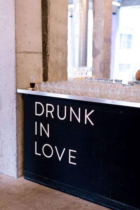 a sign that says drunk in love on the side of a wall next to a counter